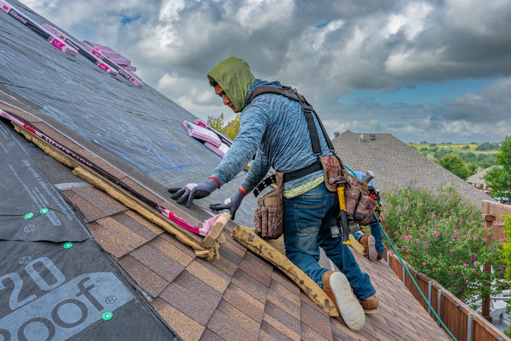 Roofer installing architectural asphalt shingles on foam pads